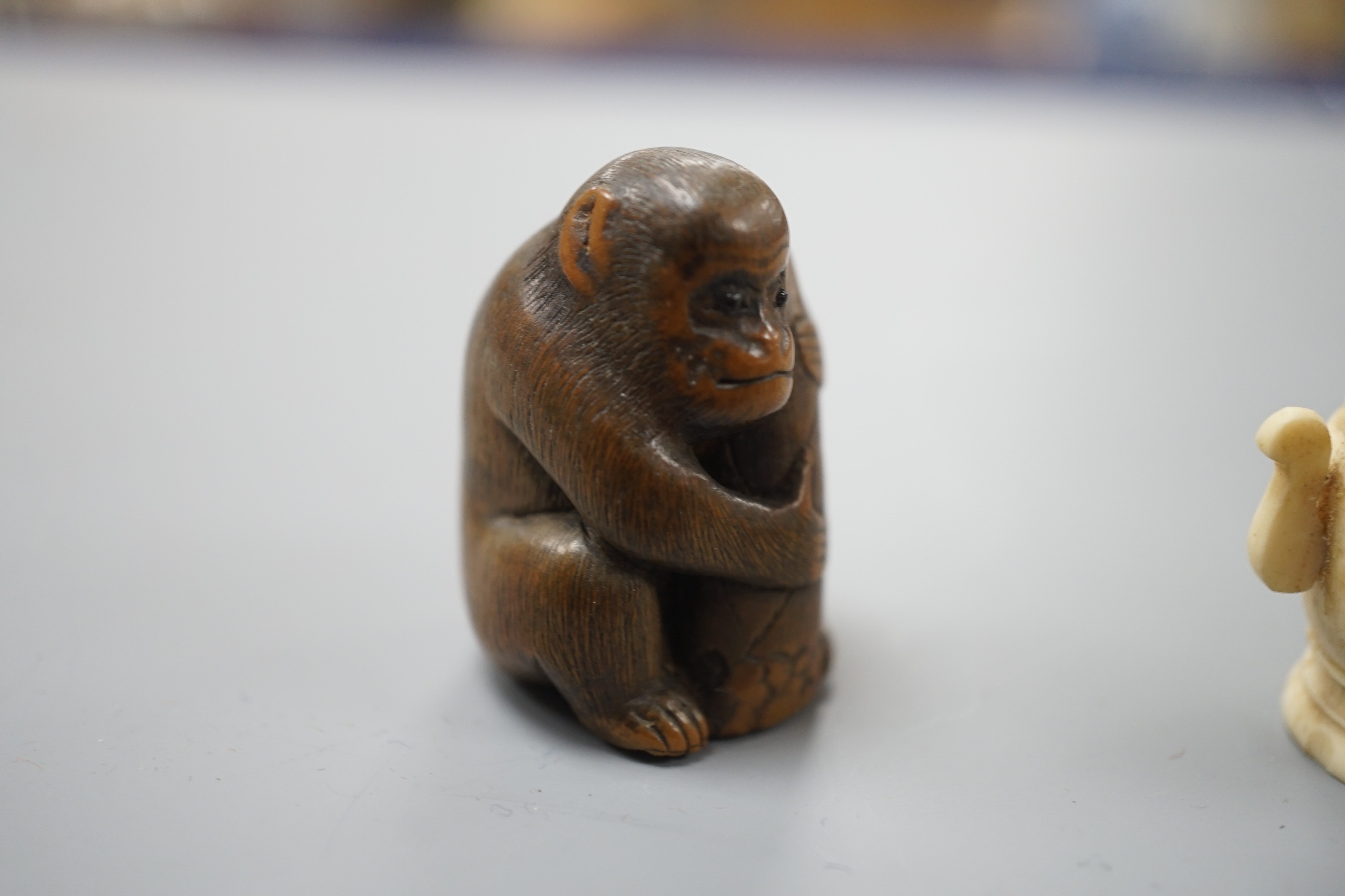 A pair of early 20th century Japanese miniature ivory vases, 5.3 cm, engraved with a lady and a wood netsuke in the form of a monkey holding a bamboo shoot (3)